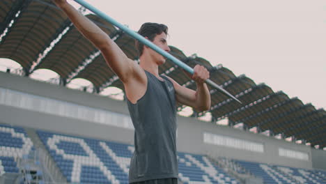 javelin-throw-back-athlete-thrower-in-track-and-field-event.-Undefined-athlete-javelin-throwing-during-Athletics-Championships.-Sportsman-practising-javelin-throw-against-blue-sky-with-clouds